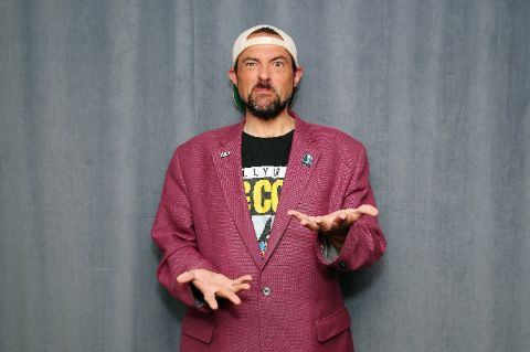 Kevin Smith in a red coat poses for a picture.